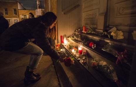 A woman places a candle in front of the home of Leonard Cohen in Montreal.
