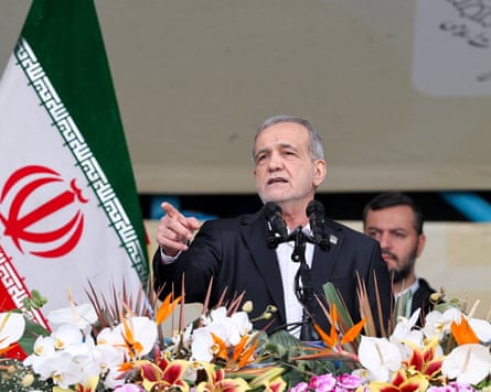 Masoud Pezeshkian speaks to a crowd from a raised platform