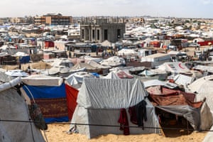 Hundreds of tents surround only one or two surviving structures of buildings