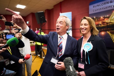 Farage tregon diçka pas fotografëve ndërsa qëndron pranë Sarah Pochin