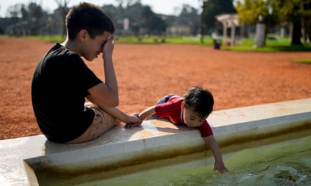 A child dips his hand in a fountain at a park in Buenos Aires, Argentina 