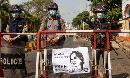 Police stand guard during protests in Yangon on Sunday