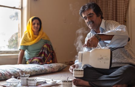 Hekmatullah, an Afghan refugee, pours chai as his wife Waheeda watches on. Hekmatullah worked as a journalist for 25 years before coming to America. He now works in a retail distribution center in Atlanta.