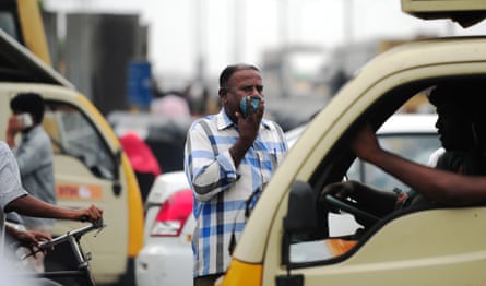 An Indian commuter wears a mask to protect himself against dust and pollution as he waits to cross a road in Chennai.