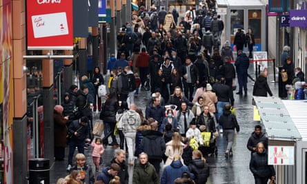 People walk along a busy shopping street in the traditional Boxing Day sales in Liverpool, Britain, on 26 December 2021.