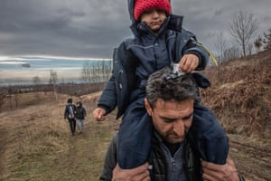Ibrahim, 46, carries his son through the the woods of Bosanska Bojna