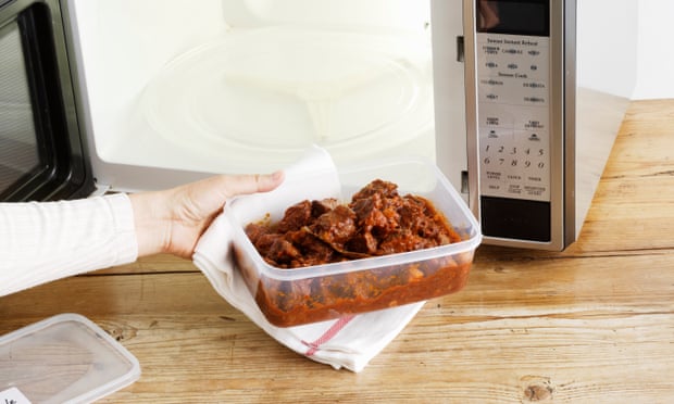 A meal in a plastic container and a microwave