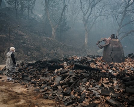 A monk looks at a cracked temple bell remaining after a wildfire destroyed most of the buildings at the Gounsa temple in Uiseong, South Korea