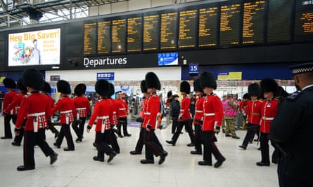 Des membres des forces armées participant aux cortèges du couronnement arrivent à la gare de Waterloo à Londres