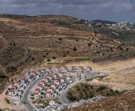Rows of newly built homes and roads on a hillside.