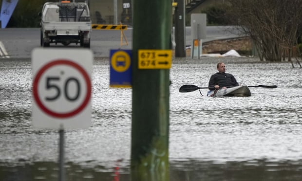 A man paddles his kayak through a flooded street on the outskirts of Sydney, Australia, earlier this week. 