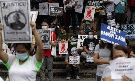 rotesters hold pictures of human rights activists killed in the Philippines