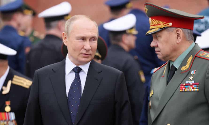 President Vladimir Putin speaks with defence minister Sergei Shoigu during a wreath-laying ceremony yesterday at the Tomb of the Unknown Soldier in Moscow
