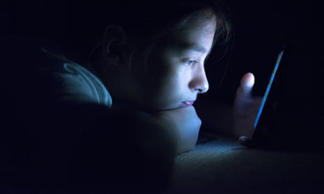 A child using a smart phone at night time