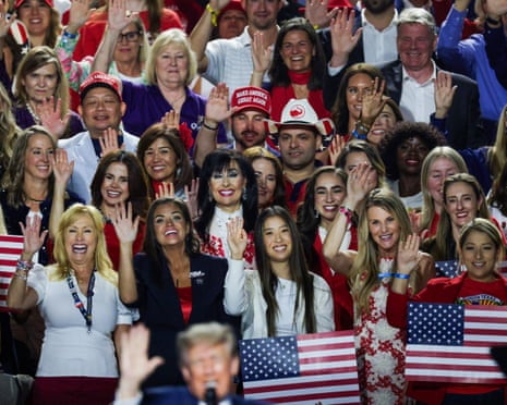 People raise there hands to take a pledge as directed by Donald Trump on the second night of the Republican midterm convention in Dallas.