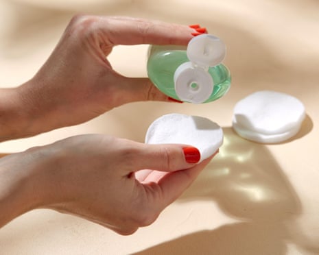 Someone applies toner to a cotton pad