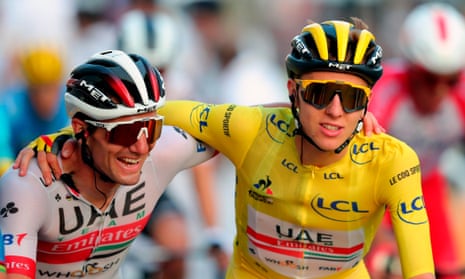 Tadej Pogacar (right) is embraced by a teammate before crossing the finish line on the last stage of the Tour de France