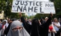 A woman shows a sign saying "Justice for Nahel" during a march for 17-year-old Nahel, who was killed by police.