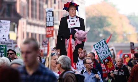 Protesters with lifesize cut-out of David Cameron with a pig protruding from his crotch and a sign around neck saying 'I am a grunt'.