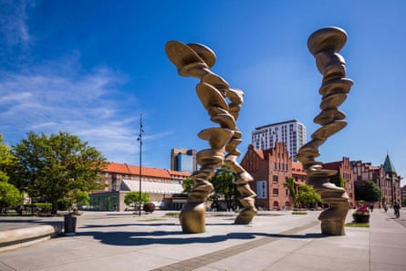 A public artwork of three pillars made from stacked pieces of sculpture.