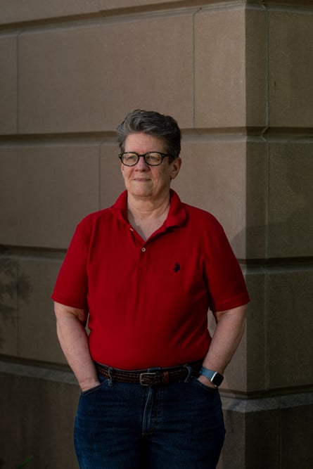 Woman in red shirt stands with hands in pockets