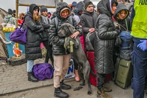 A Ukrainian woman and her dog wait in a queue of people at the reception centre in Medyka.