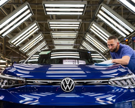 A worker assembles a new, blue Volkswagen