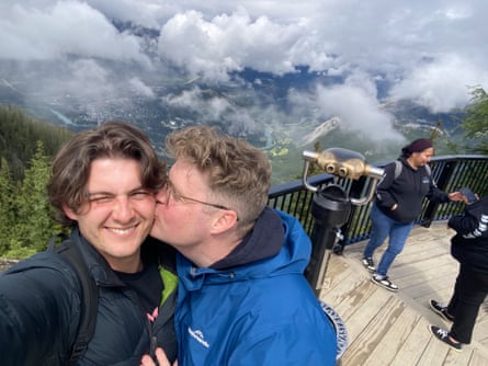 Tom Ballard kissing his partner Harley on the cheek on a mountaintop