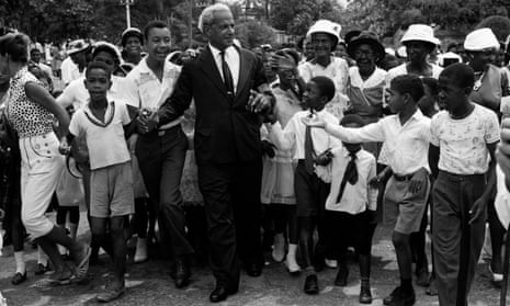 Children gather round Norman W Manley, founder of the Jamaican People’s National Party, as he makes his way to the cathedral for Jamaica’s Independence Day celebrations, 6 August 1962.