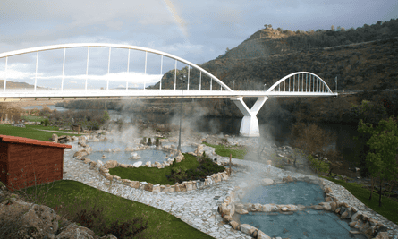 Outariz and Burga de Canedo thermal baths, demarcated by rocks and crossed by a white bridge