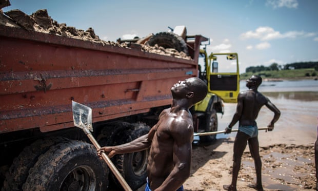 Sand diggers loading trucks at a quarry on the banks of the Congo river.