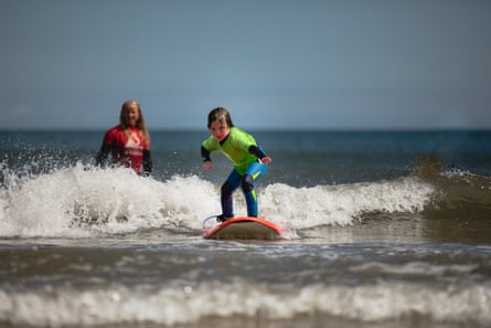 A young child surfs towards the camera