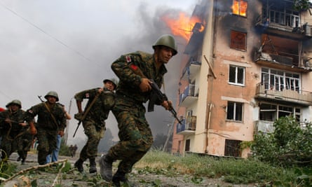 Georgian soldiers run past a blazing building after a Russian bombardment in Gori in August 2008.