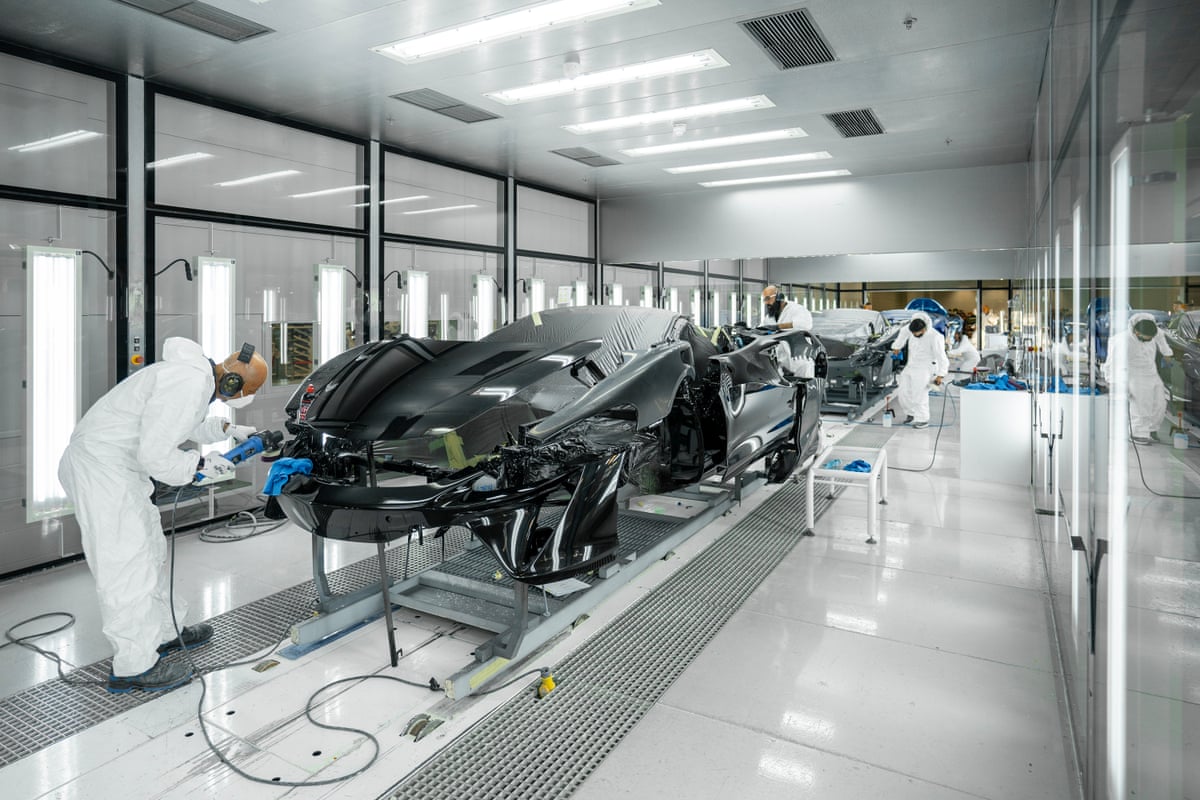 People working on a row of sports cars
