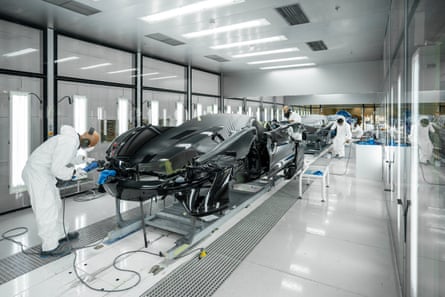 People working on a row of sports cars