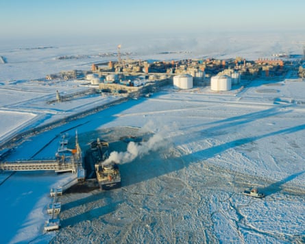 A frozen river with ships on it and a factory