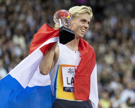 Niels Laros with the Dutch flag draped over his shoulders, lifts the trophy after winning the men’s 1500m during the 2025 Diamond League final