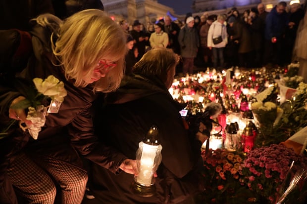 A woman lights a candle outside Warsaw’s Palace of Science and Culture to commemorate Piotr Szczesny.