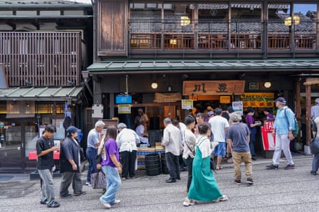 Busy street in Narita, Japan, with people flocking to a restaurant to buy eel.