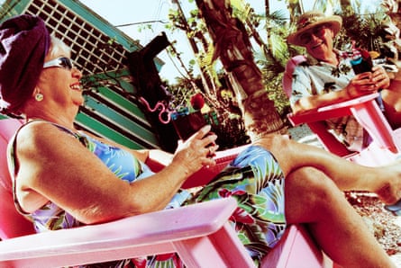 Two older people sit in deck chairs and smile.