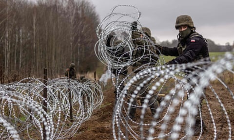 Polish soldiers build a concertina fence on the Polish-Russian border