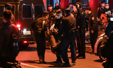 A man is arrested as people gather on a street in Shanghai on 27 November.