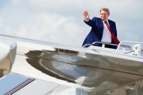 a man waves at the top of a staircase outside a plane