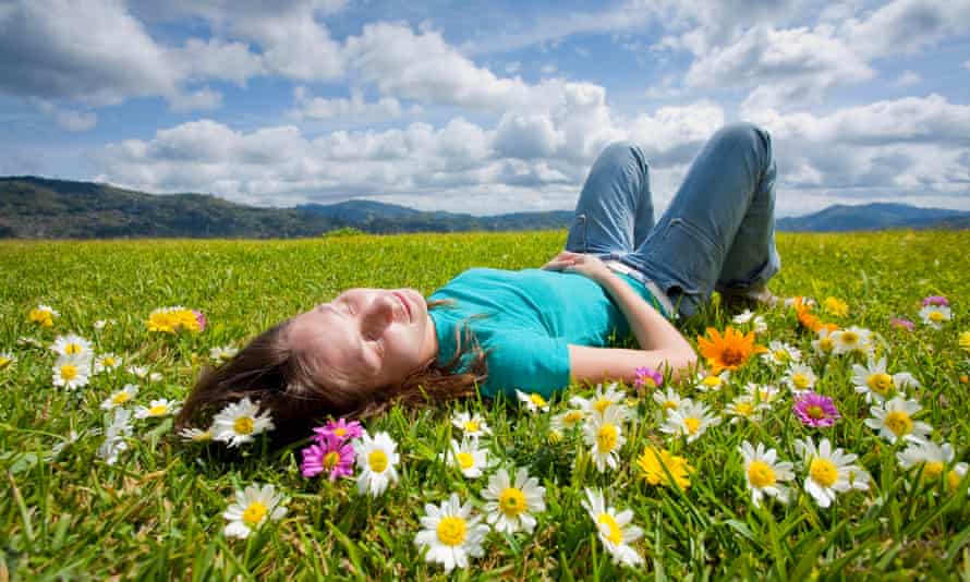 a young woman lying in a meadow with flowers