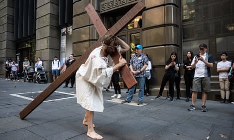 A man portraying Jesus carries a cross during a Good Friday Crucifixion Walk, in Martin Place, Sydney, Australia