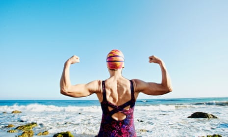 Woman flexing her muscles on beach