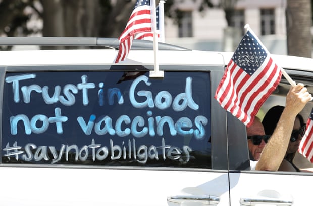 Demonstrators participate in a vehicle caravan with a sign reading ‘Trust in God not vaccines’ in Los Angeles.