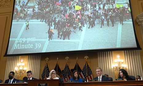 Members of the House January 6 committee are seen as video of the US Capitol is displayed behind them during a hearing in July. 