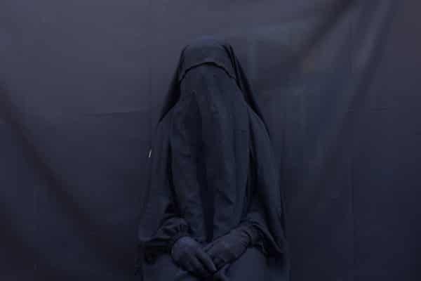Yazidi Layla Taloo poses for a portrait in the full-face veil and abaya she wore while enslaved by Isis militants, at her home in Sharia, Iraq.