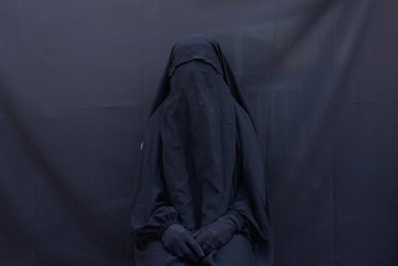 Yazidi Layla Taloo poses for a portrait in the full-face veil and abaya she wore while enslaved by Isis militants, at her home in Sharia, Iraq.
